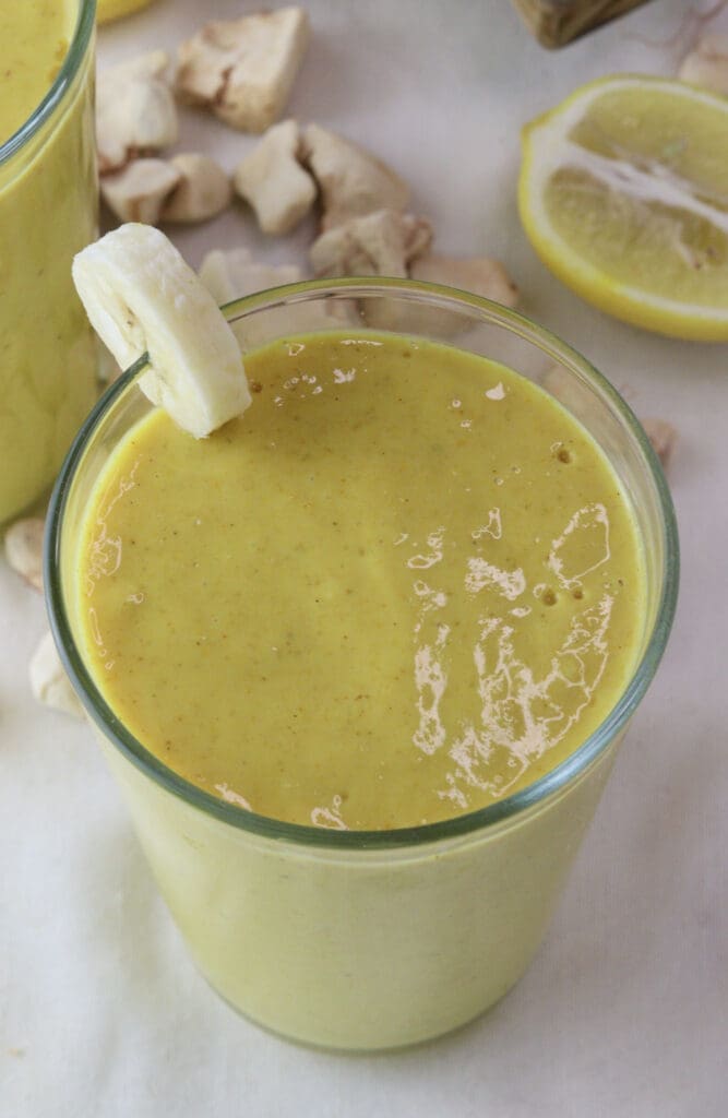 Another glass full of baobab smoothie with ginger and a banana slice.